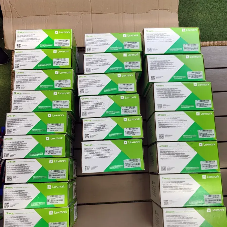 Zeci de cutii Lexmark verzi, sigilate, așezate în rânduri